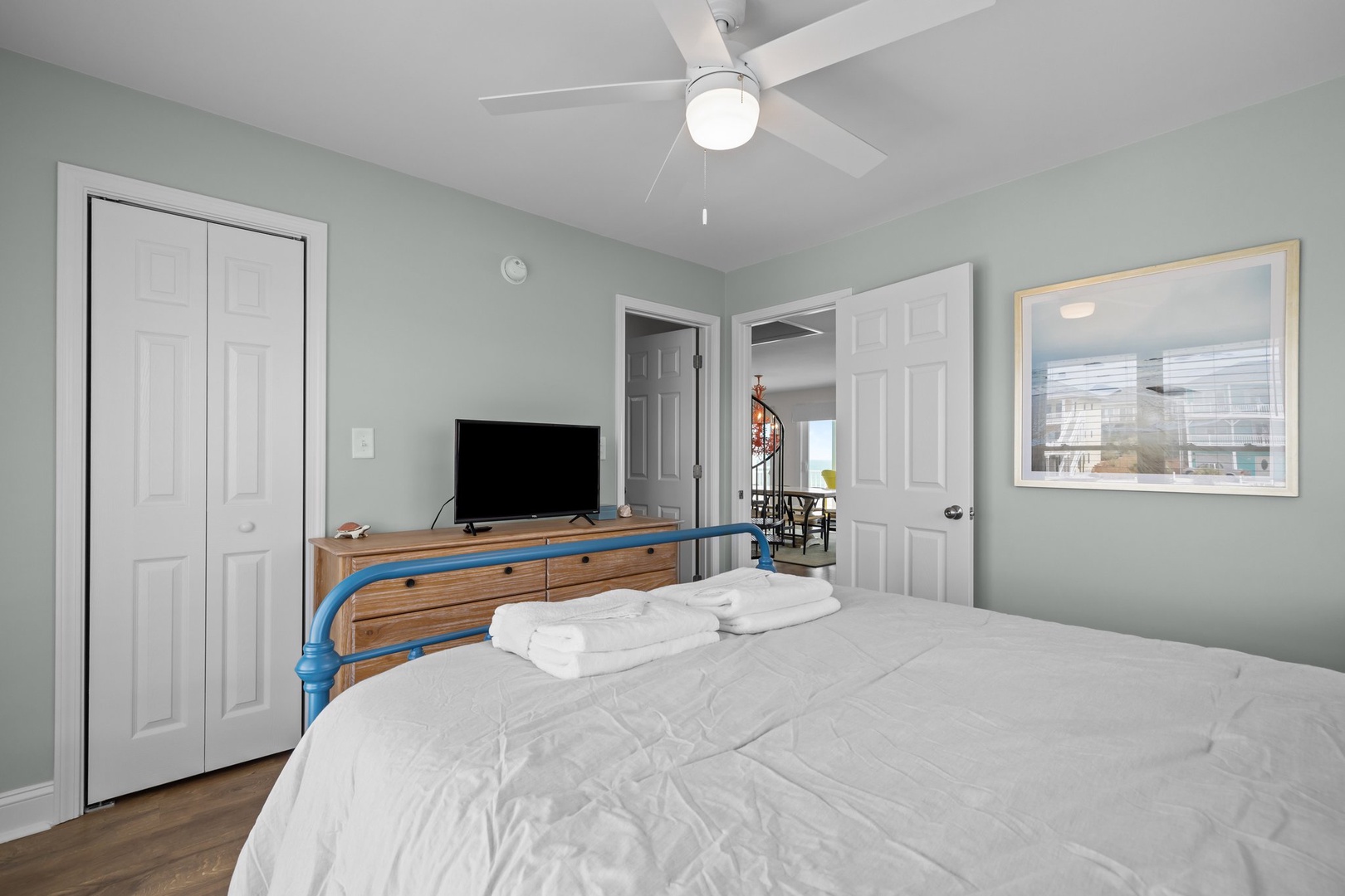 Unwind in your peaceful bedroom with soft mint walls, a ceiling fan, and entertainment center for cozy evenings.