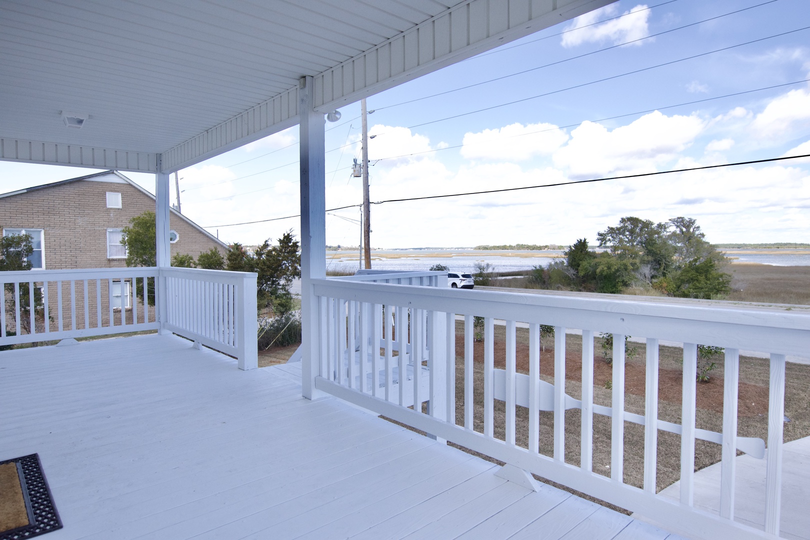 Your spacious wraparound porch invites you to unwind with stunning views of nearby wetlands and peaceful neighborhood surroundings.