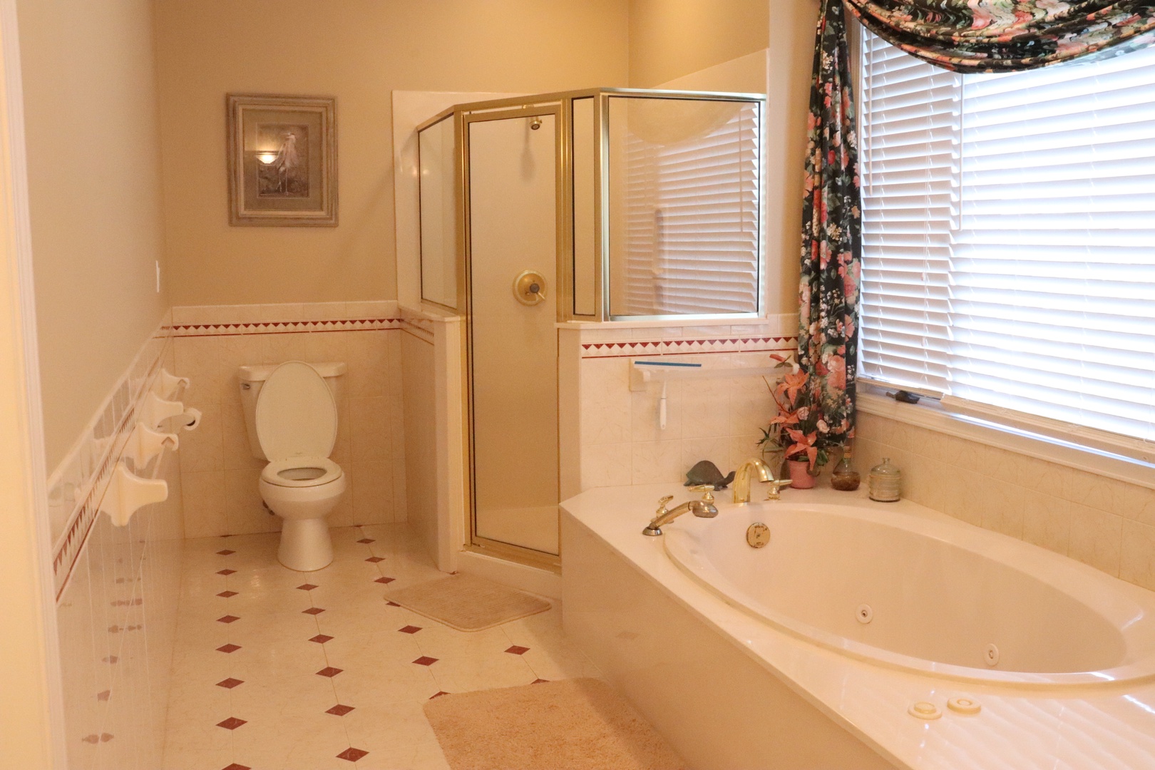 Soak your cares away in this elegant bathroom featuring a luxurious jetted tub and separate shower, all bathed in natural light from charming windows.
