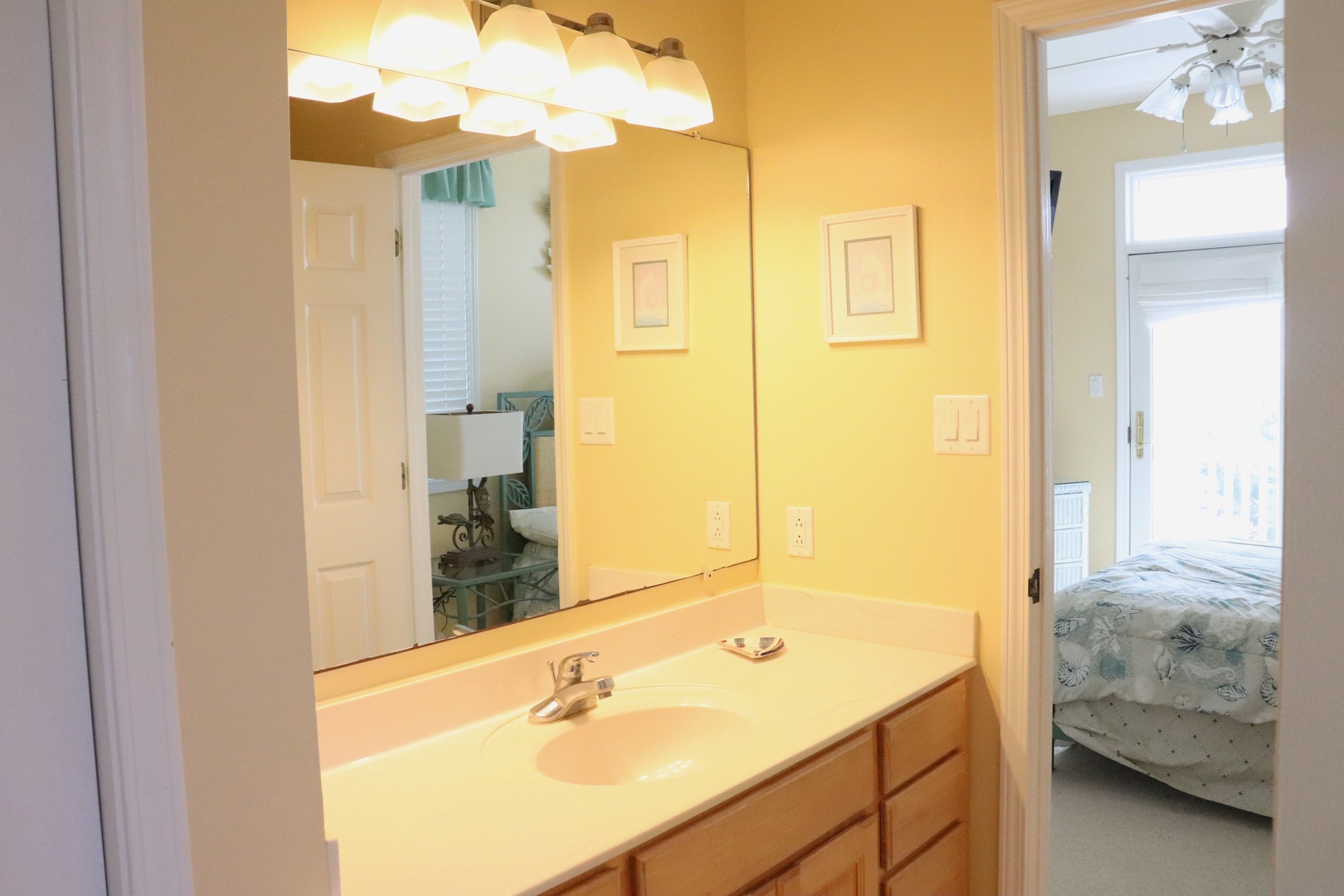 Step into your cheerful bathroom with warm lighting and ample counter space for your morning routine.
