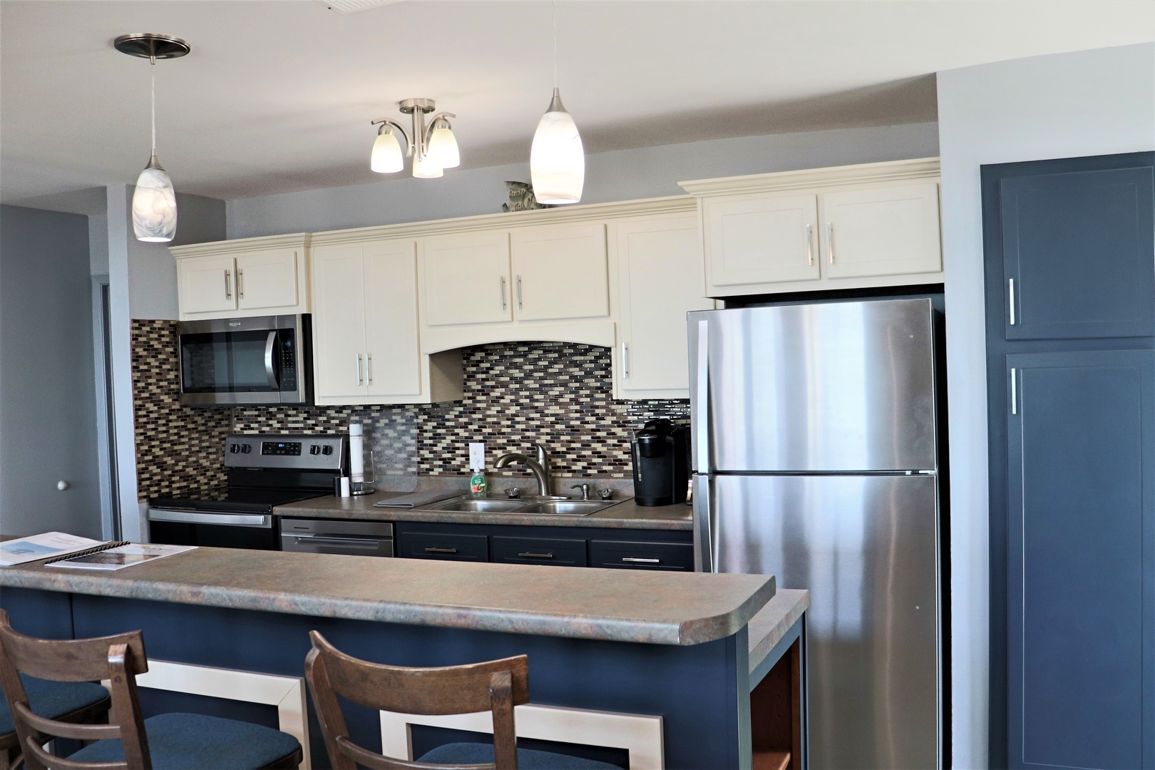 Prepare memorable meals in your modern kitchen featuring stainless steel appliances, elegant pendant lighting, and a convenient breakfast bar.