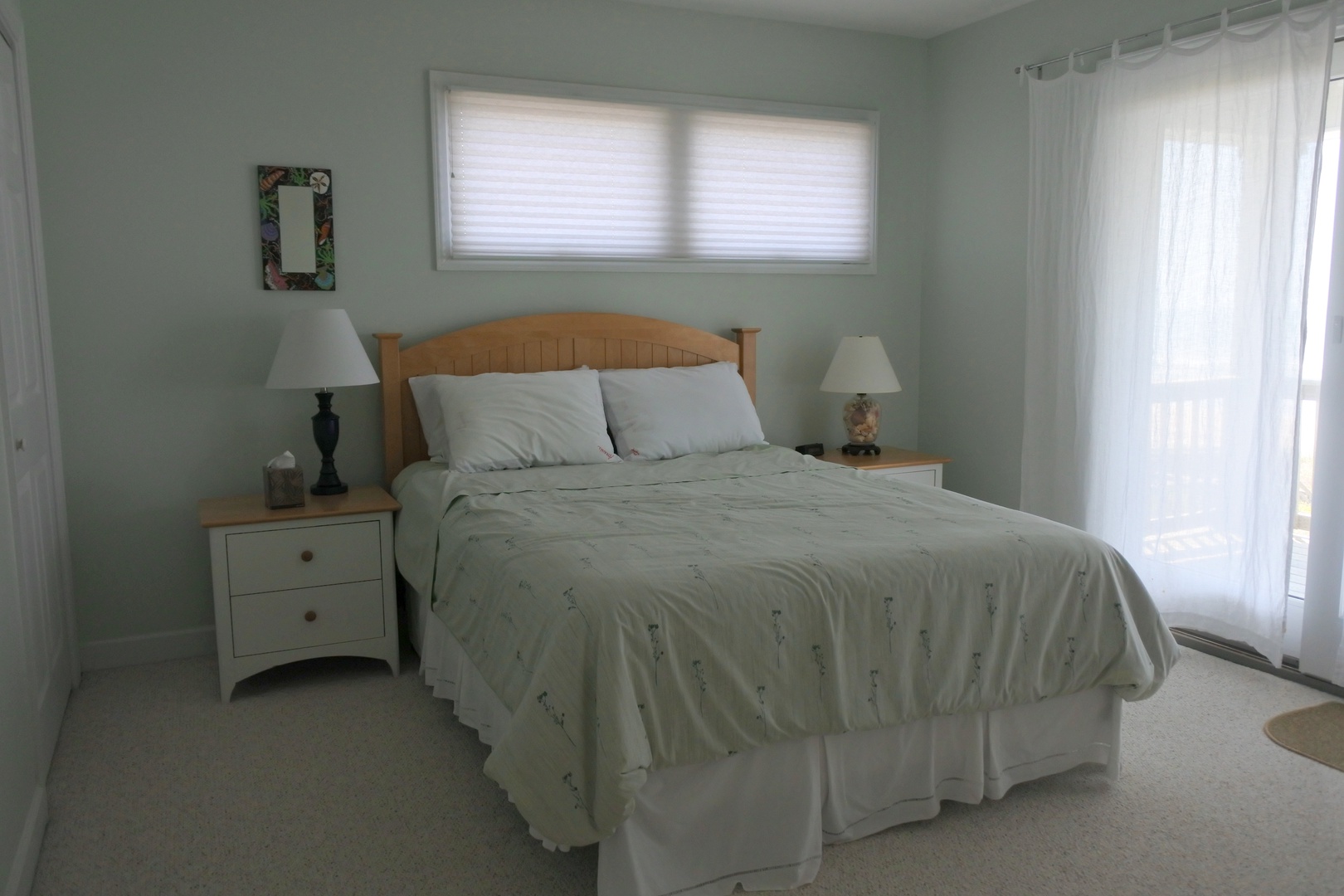 Drift off to peaceful slumber in this serene bedroom, where soft mint walls and natural light create your perfect retreat.