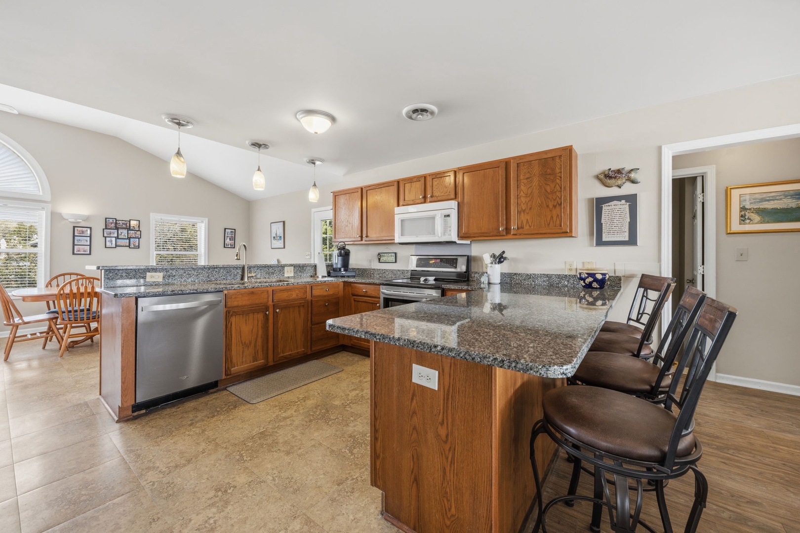 Gather around your spacious granite island where meals become memories, with gleaming appliances and warm wood cabinetry creating the perfect culinary haven.