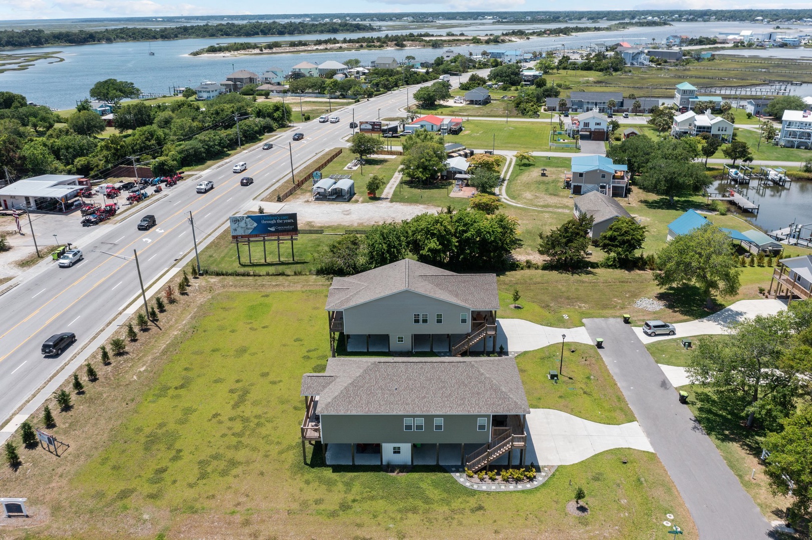 Aerial view of waterfront vacation rental properties near Outer Banks coastline with easy highway access and natural surroundings.