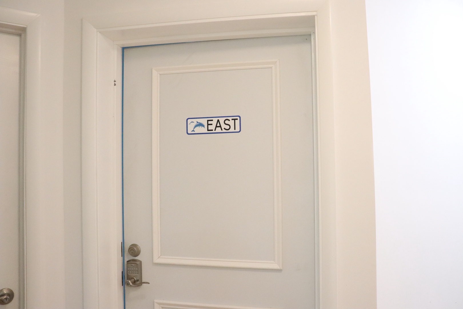 The East unit entrance, featuring a cheerful dolphin motif, marks your arrival to this coastal retreat.