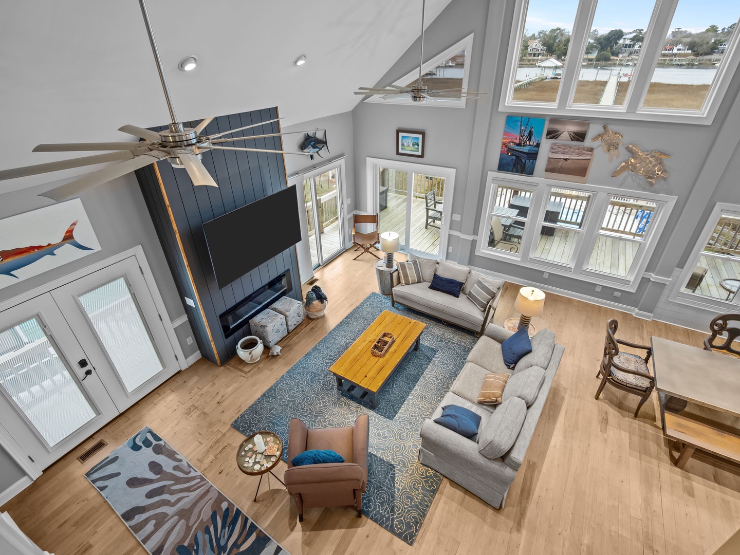 Step into your stunning waterfront living room where soaring ceilings and oversized windows frame peaceful water views.