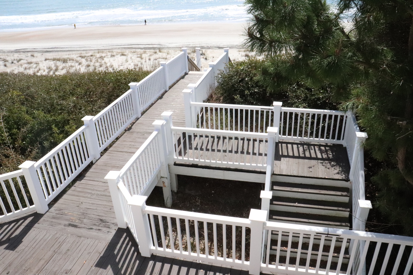 Private beach walkway leads directly to pristine sandy shores and rolling waves at your oceanfront retreat.