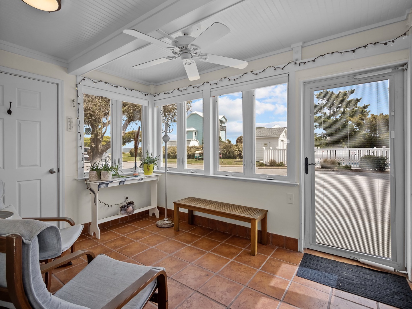 Relax in your sunny enclosed porch with panoramic windows, cozy seating, and charming tile floors—perfect for morning coffee or afternoon reading.