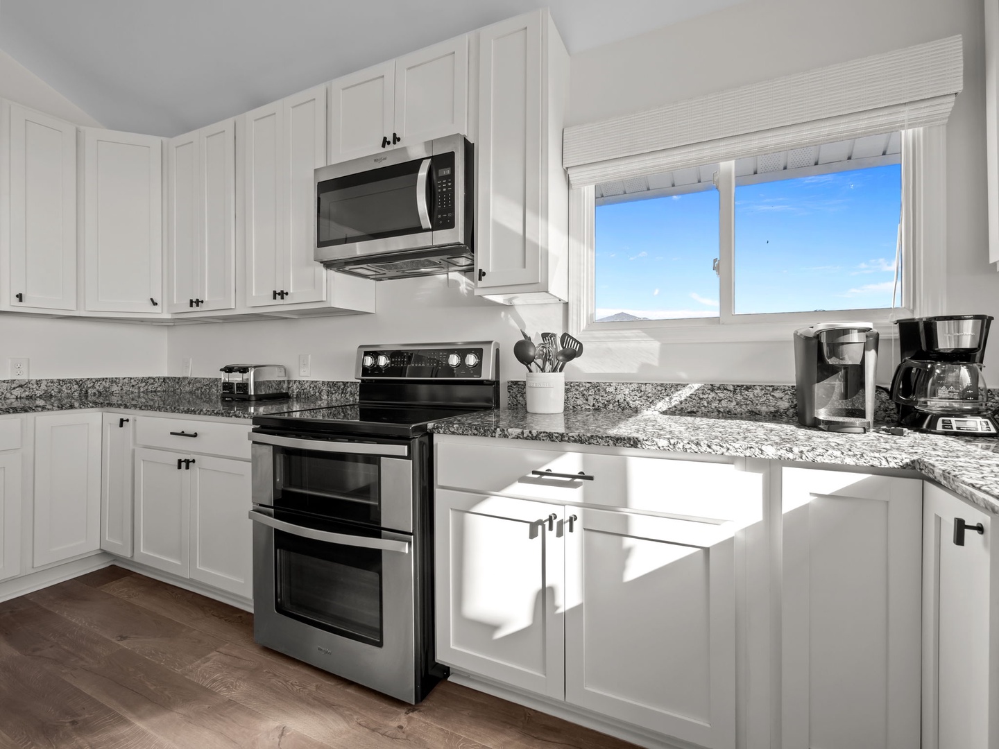 Your fully equipped kitchen features granite countertops, stainless steel appliances, and a sunny window view - perfect for preparing meals together.