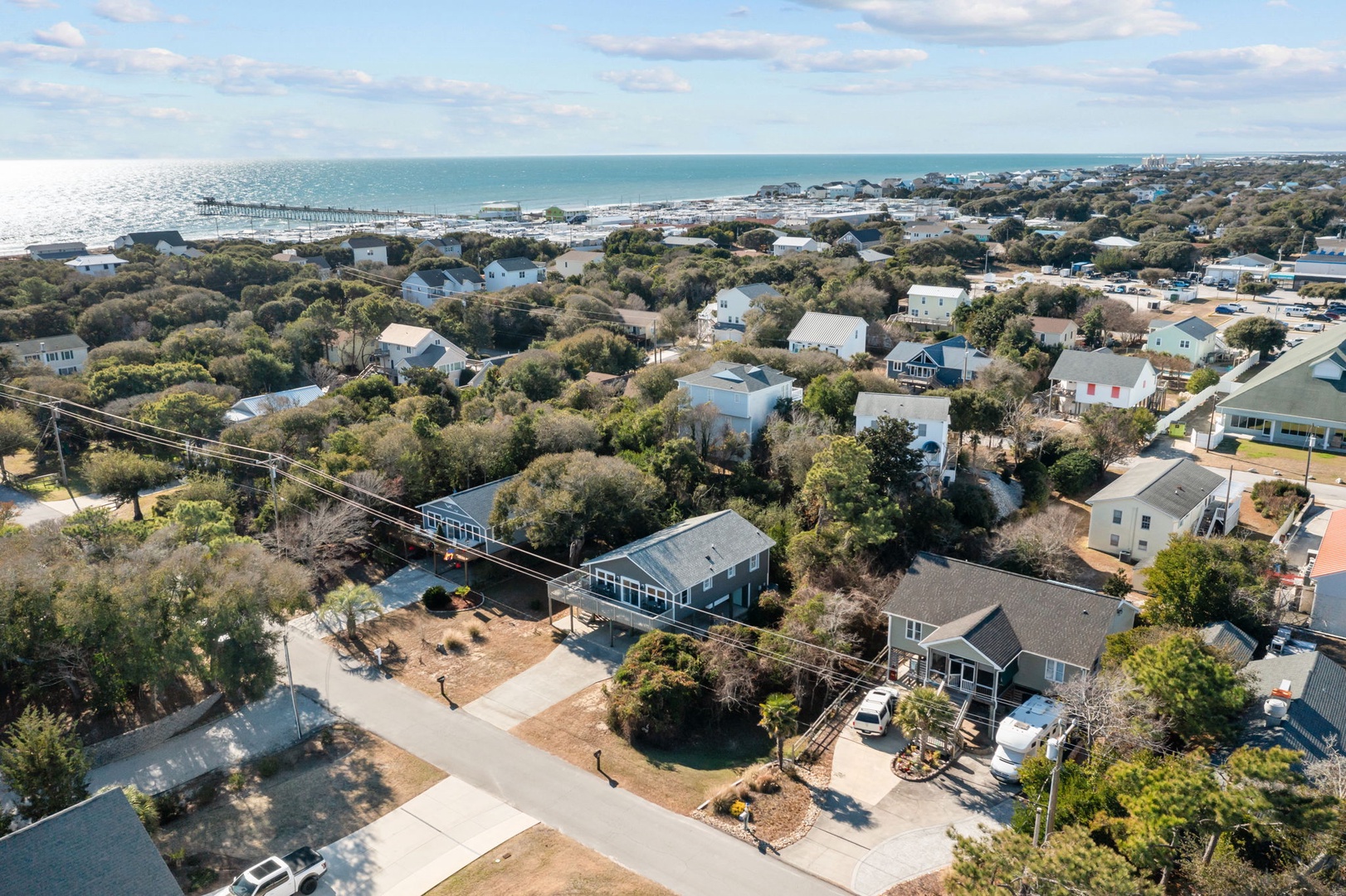 Aerial view of coastal neighborhood showcasing beach access and charming residential community near the ocean.