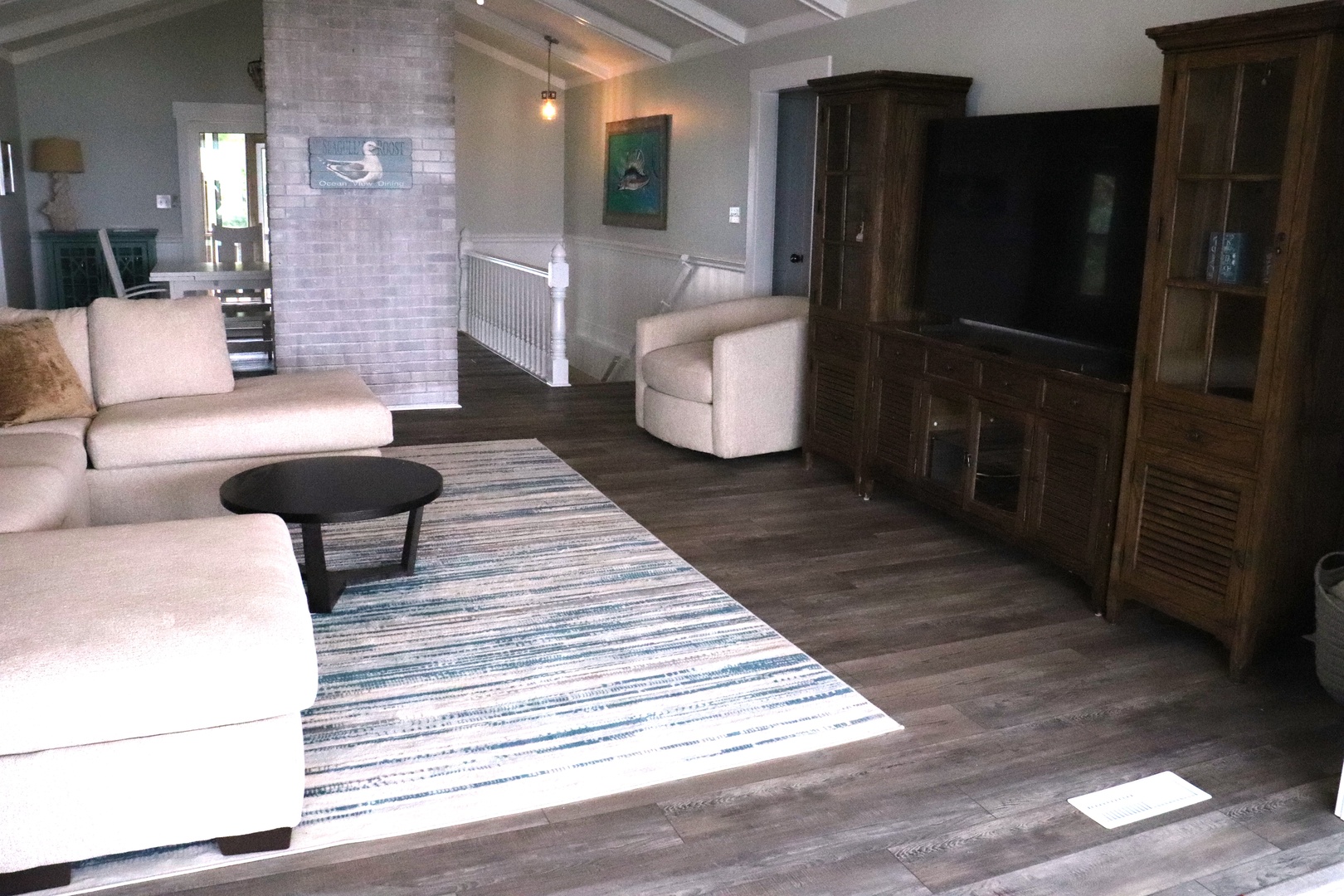 Relax in your spacious living room with plush seating, warm wood accents, and a cozy entertainment center perfect for movie nights.