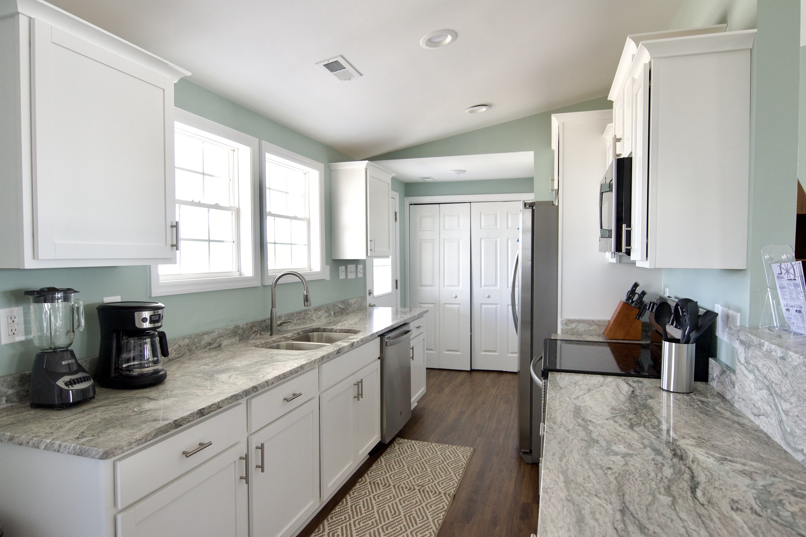 Cook with ease in this fully-equipped kitchen featuring granite countertops, modern appliances, and plenty of prep space for your vacation meals.