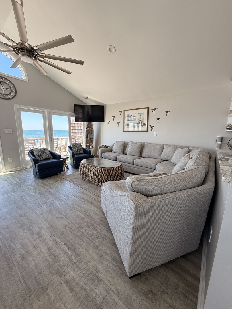 Settle into your spacious living room with coastal charm, where soft seating and thoughtful decor invite you to unwind after sunny beach days or explore nearby attractions.