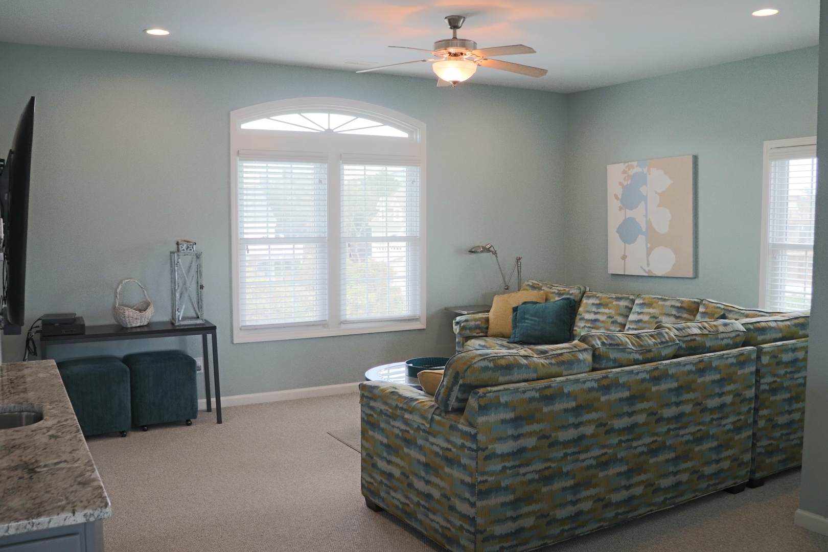 Unwind in your spacious living room with plush seating, modern decor, and natural light streaming through elegant arched windows.