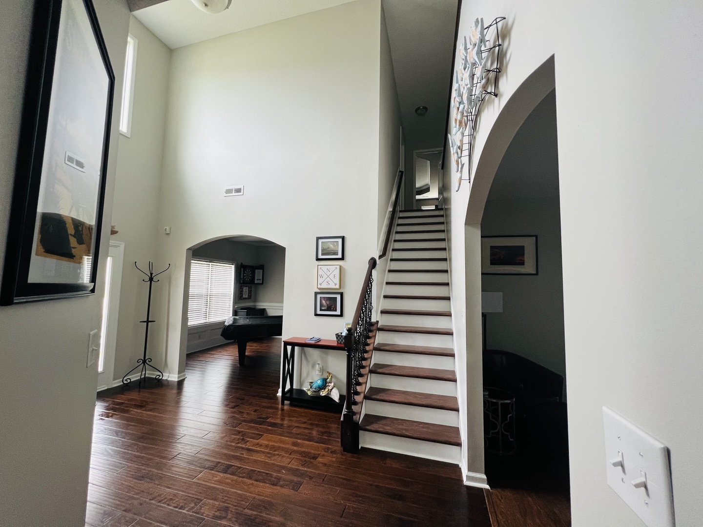Step into your elegant foyer with soaring ceilings, rich hardwood floors, and graceful staircase leading to your private upper level retreat.