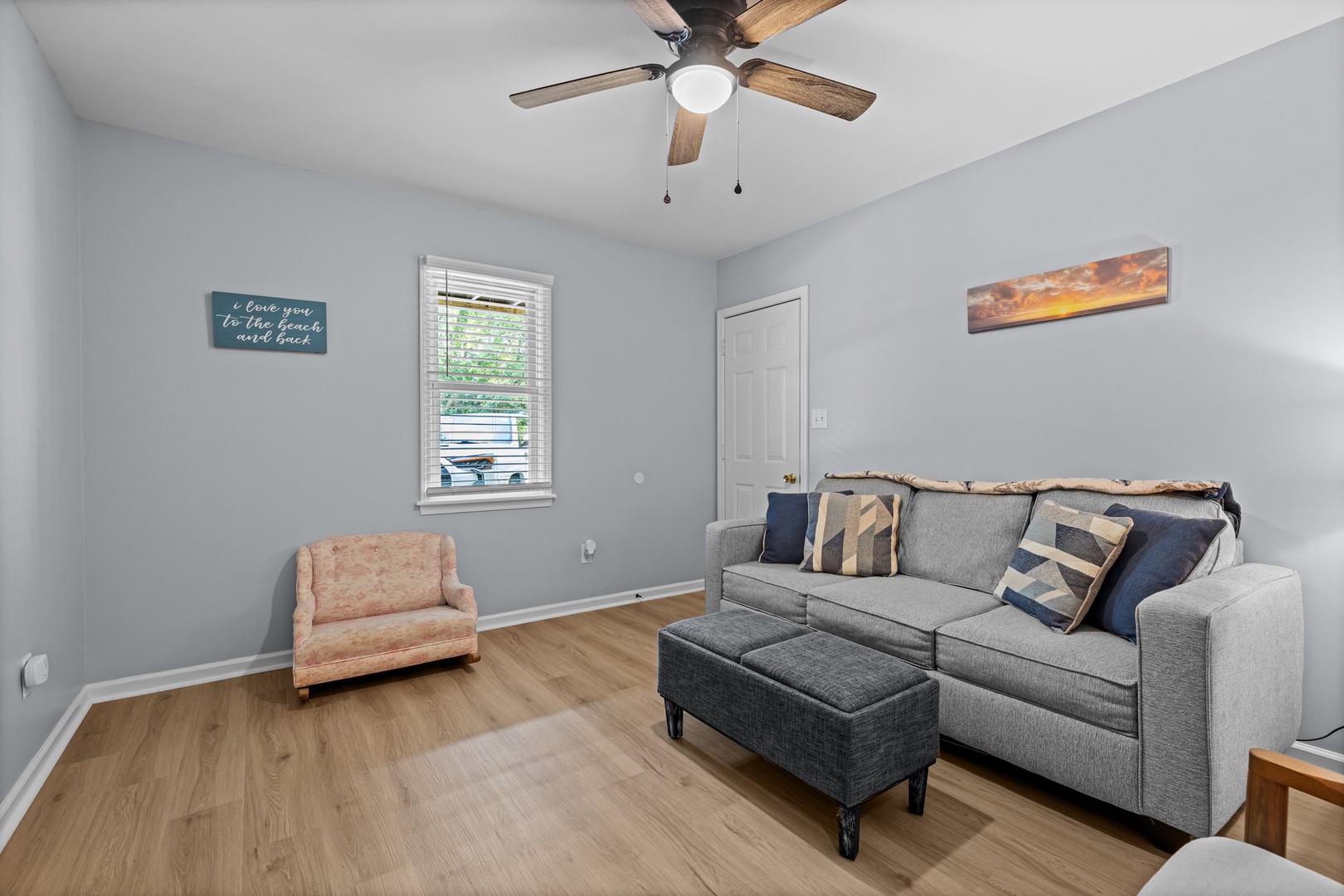 Your cozy living room awaits with plush seating, natural light, and a ceiling fan to keep you comfortable year-round.