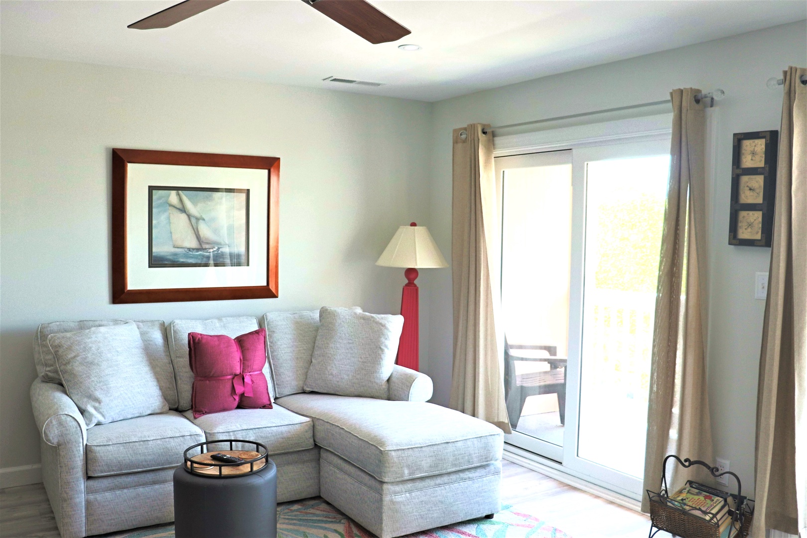 Sink into this cozy sectional where natural light streams through sliding doors to your private balcony, creating the perfect spot to unwind.