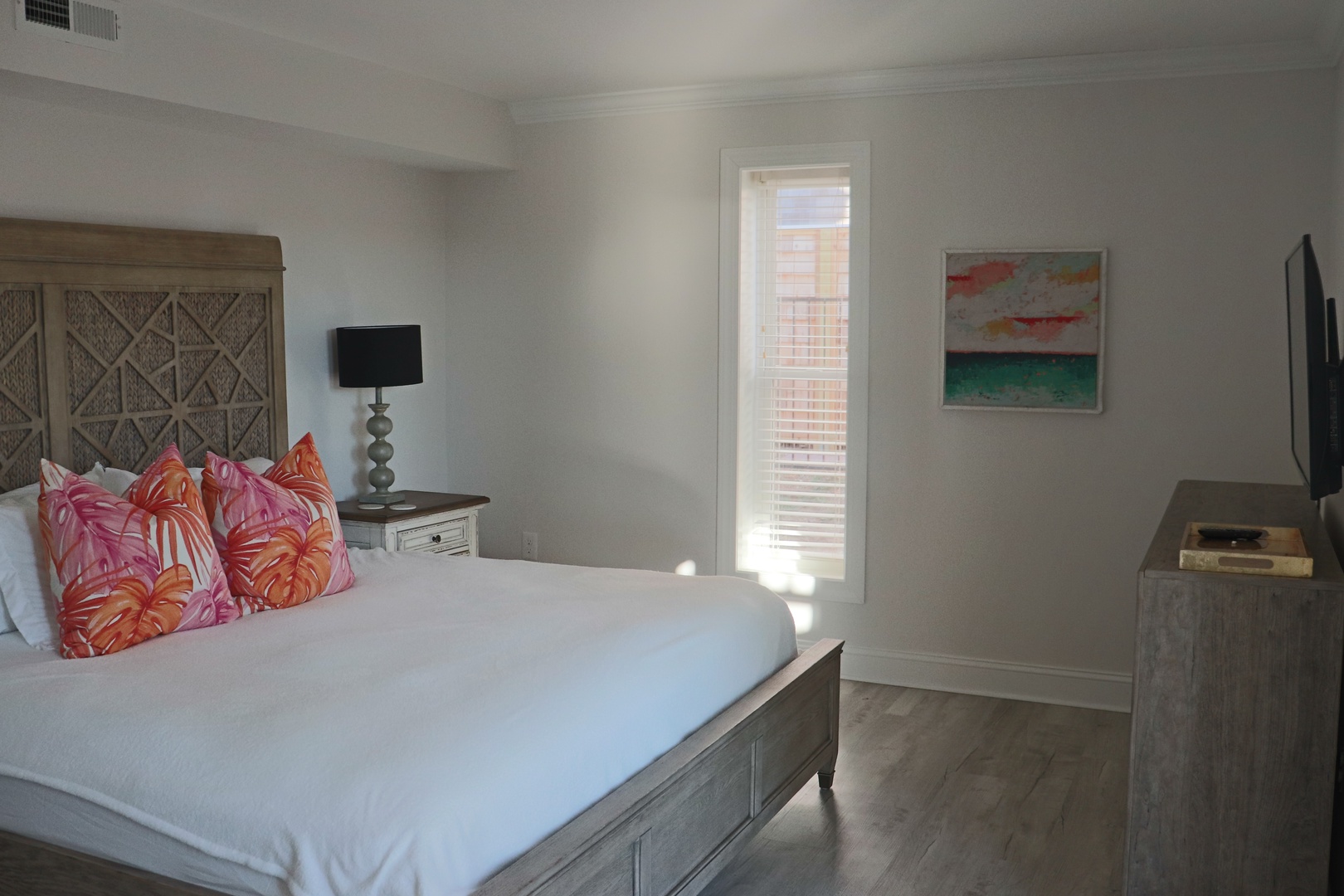 Sink into this serene bedroom with tropical-inspired pillows, natural light streaming through your window, and modern coastal artwork to frame peaceful nights.