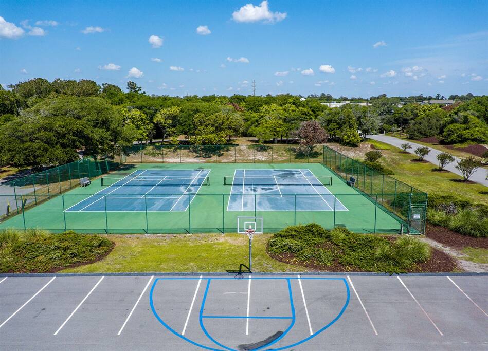 Well-maintained tennis courts and basketball area surrounded by lush landscaping offer active recreation in a peaceful setting.