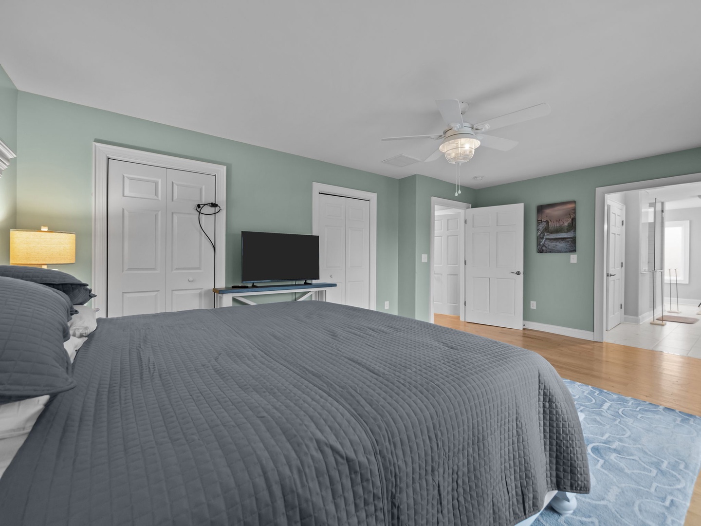 Drift off to sleep in your serene master suite with calming sage walls, hardwood floors, and modern ceiling fan.