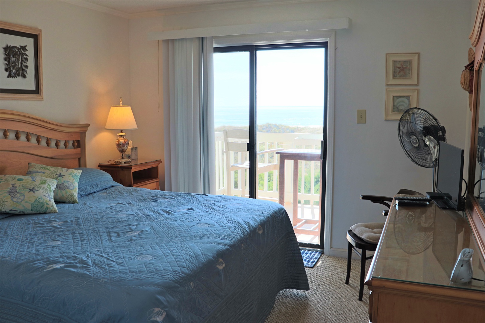 Wake up to serene views from your cozy bedroom, where ocean-themed linens invite peaceful sleep and your private balcony awaits morning coffee moments.