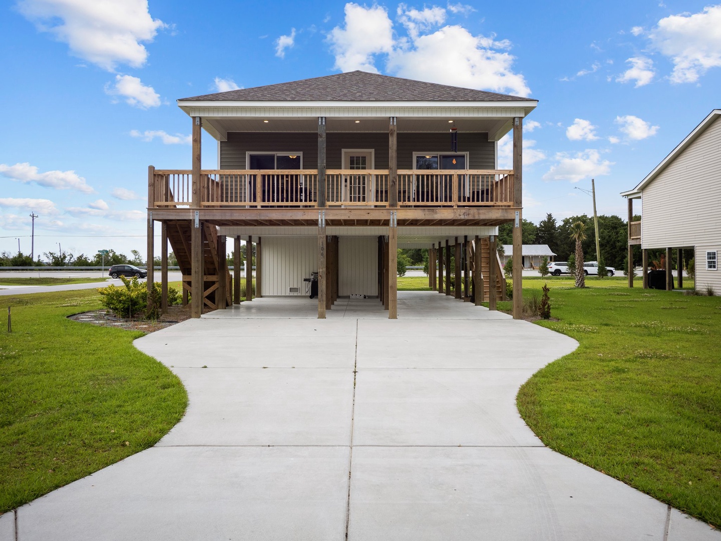 Elevated beach house with spacious covered porch and convenient ground-level parking in peaceful residential area.