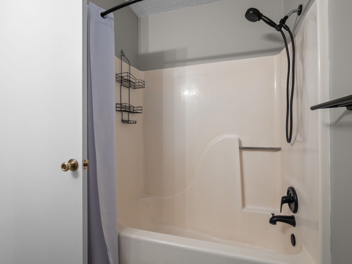 Your private bathroom features a full tub-shower combo with handheld showerhead, perfect for relaxing after your adventures.