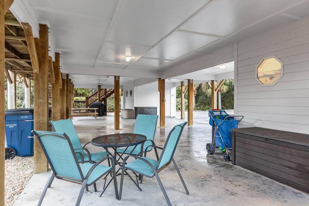 Relax at your covered outdoor dining area with turquoise chairs and table, perfect for meals with coastal breezes.
