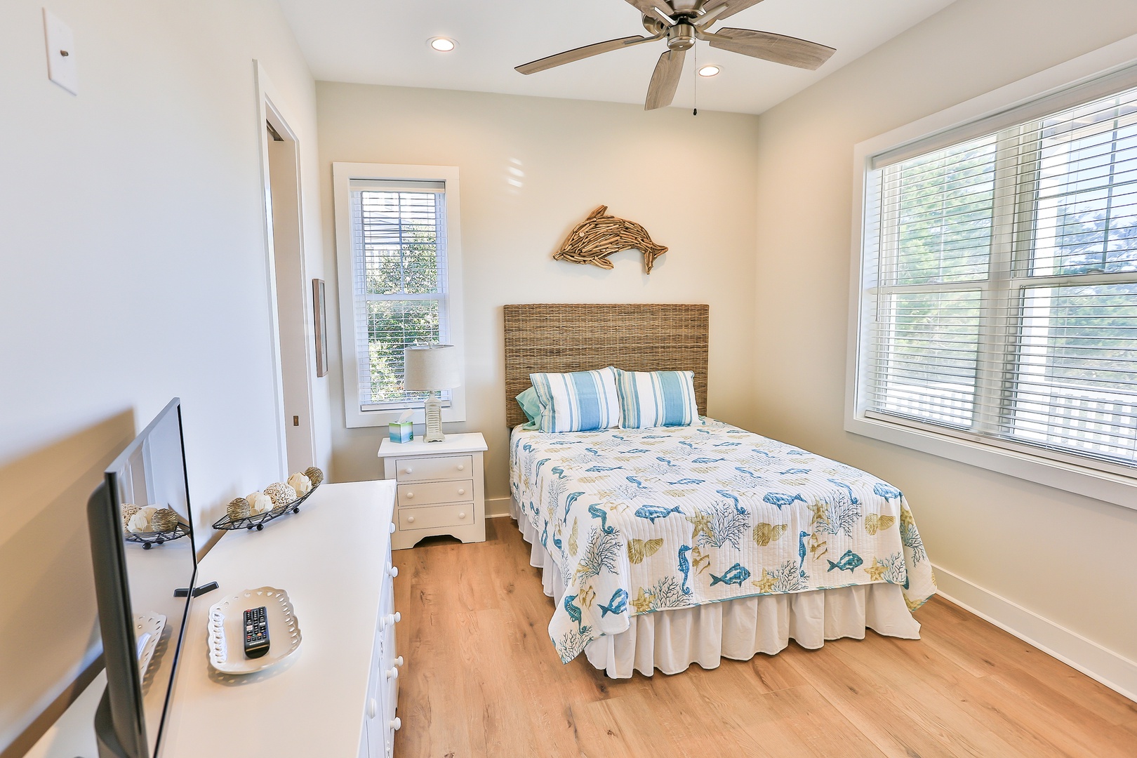 Relax in your coastal-themed bedroom with ocean-blue bedding, wicker accents, and a ceiling fan for gentle breezes.