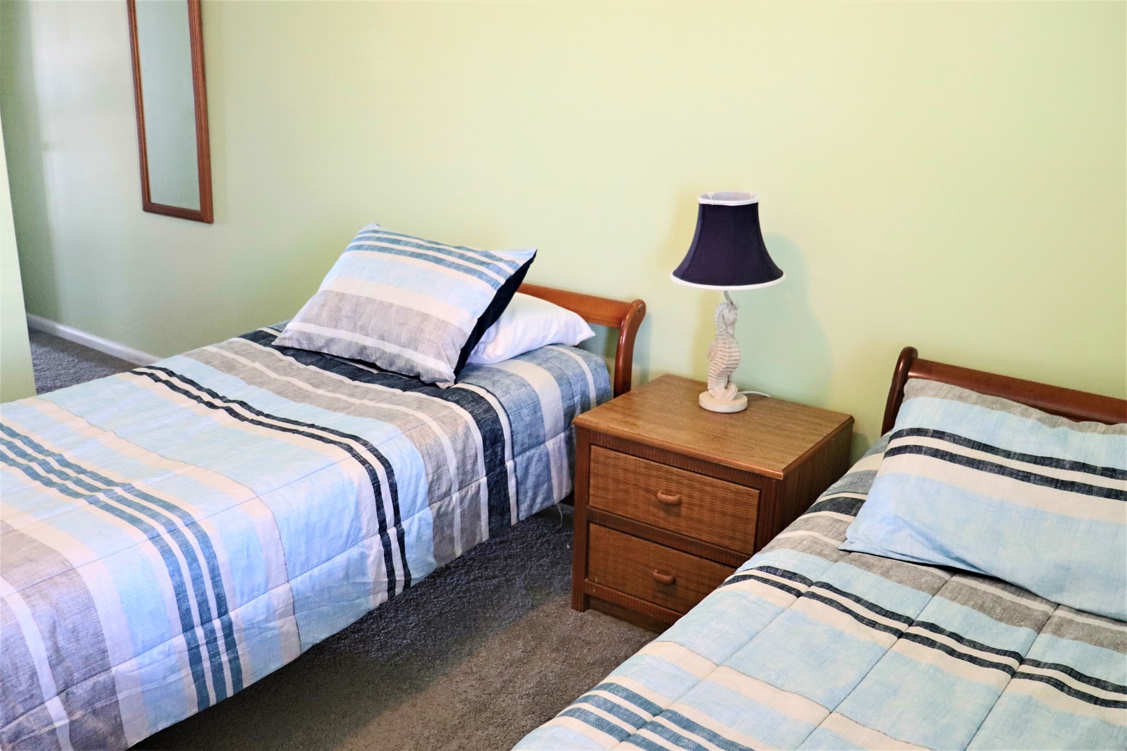 Two comfortable single beds with matching striped linens create the perfect space for friends or family sharing your getaway adventure.