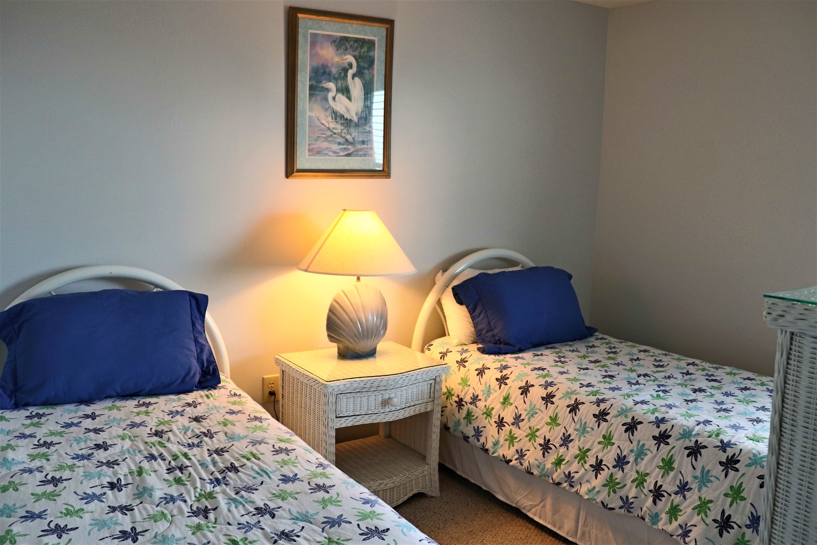 Rest peacefully in your cozy twin bedroom, where coastal charm meets comfort with thoughtful touches and warm lighting for perfect relaxation.