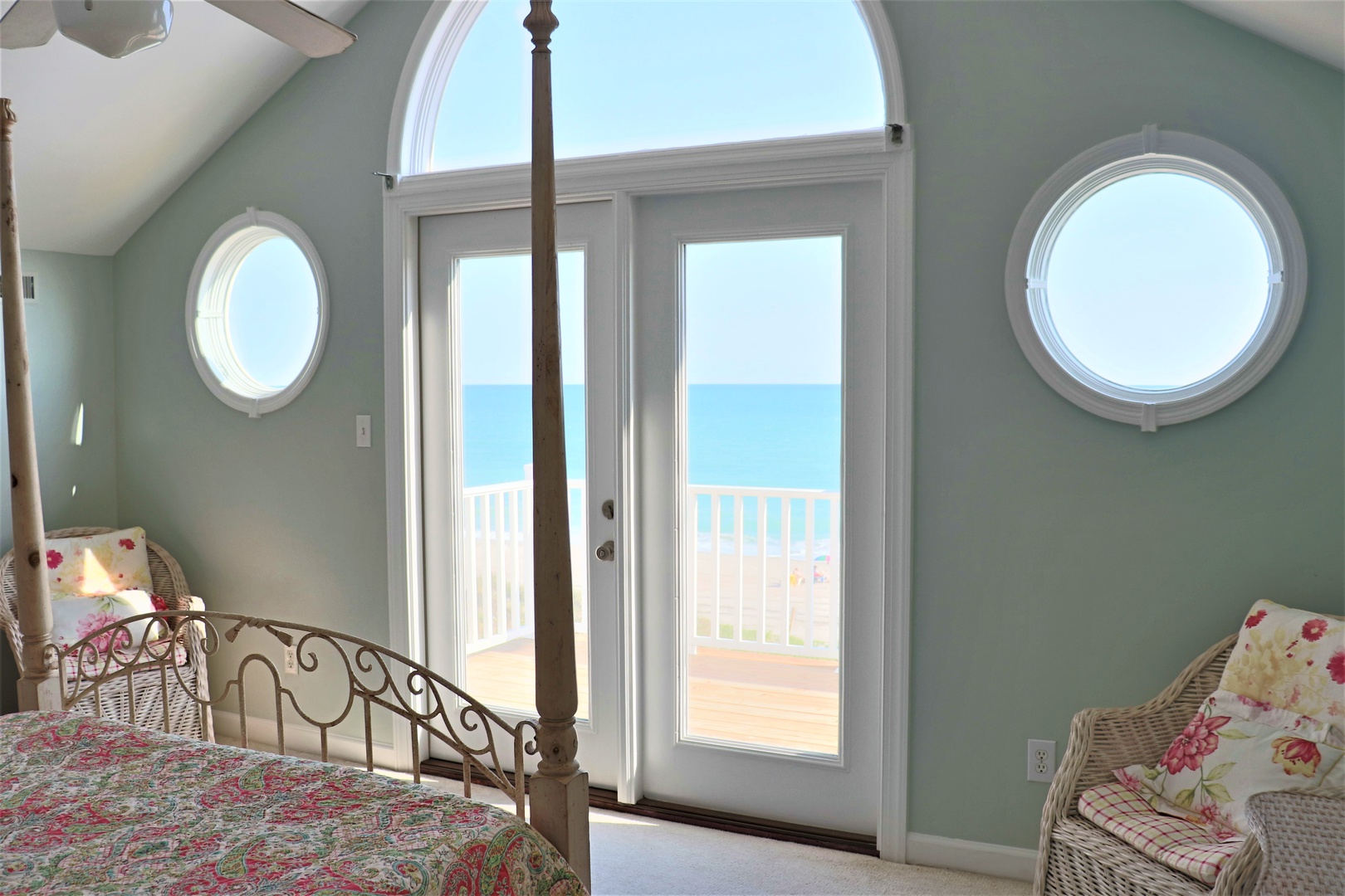 Wake up to stunning ocean views from your private bedroom balcony. Natural light fills the space through unique circular windows and French doors.