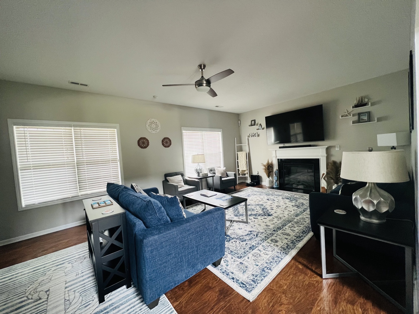 Relax in your spacious living room featuring a cozy fireplace, modern ceiling fan, and comfortable seating perfect for unwinding after your adventures.
