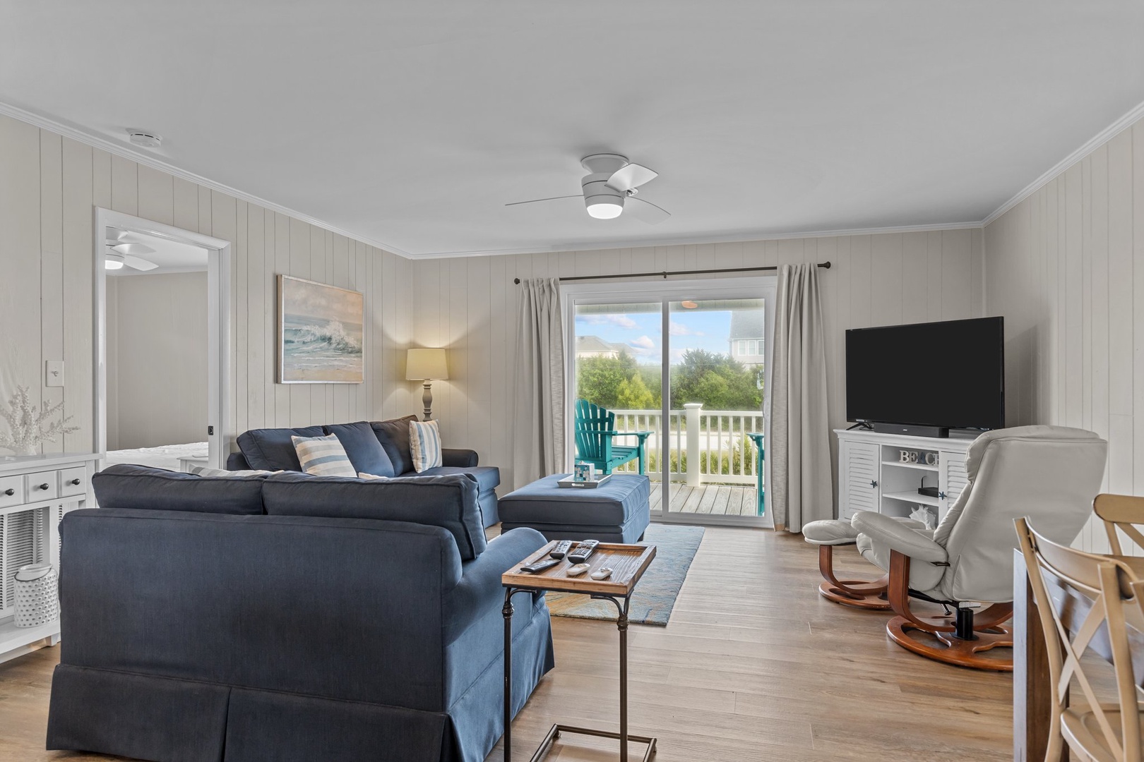 Settle into your comfortable living space with plush seating, modern TV, and sliding doors that open to your private balcony with peaceful views.