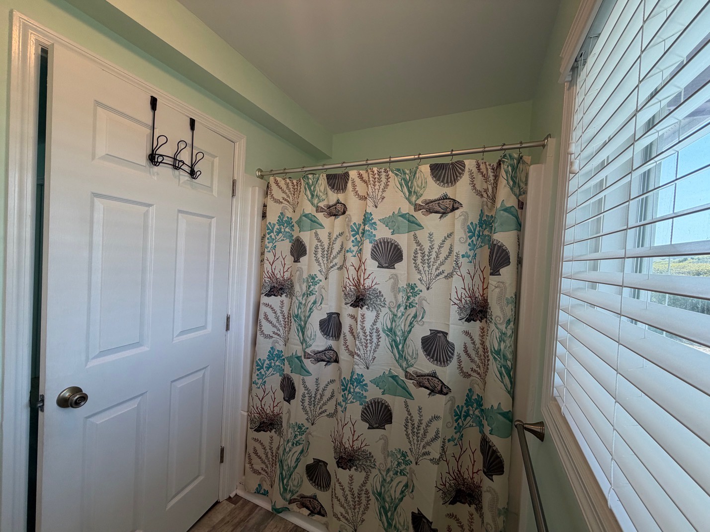 Your private bathroom features a charming ocean-themed shower curtain that brings coastal vibes to your daily routine.