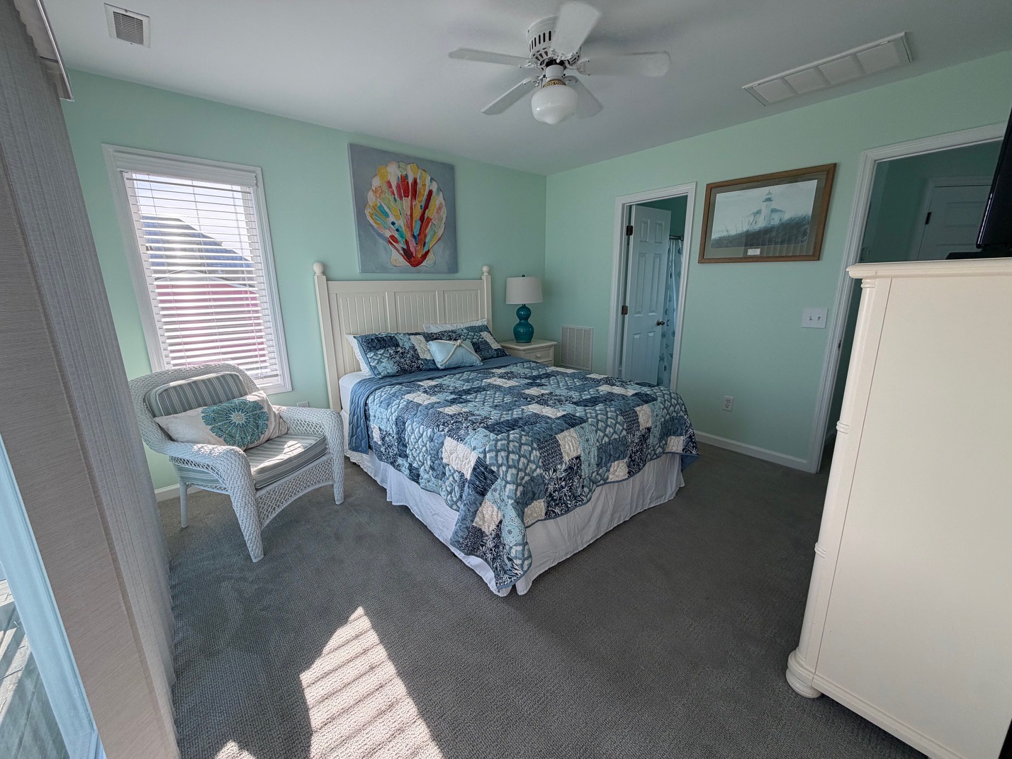 Drift off to sleep in your tranquil bedroom, where soft seafoam walls and coastal blues create a soothing seaside sanctuary.