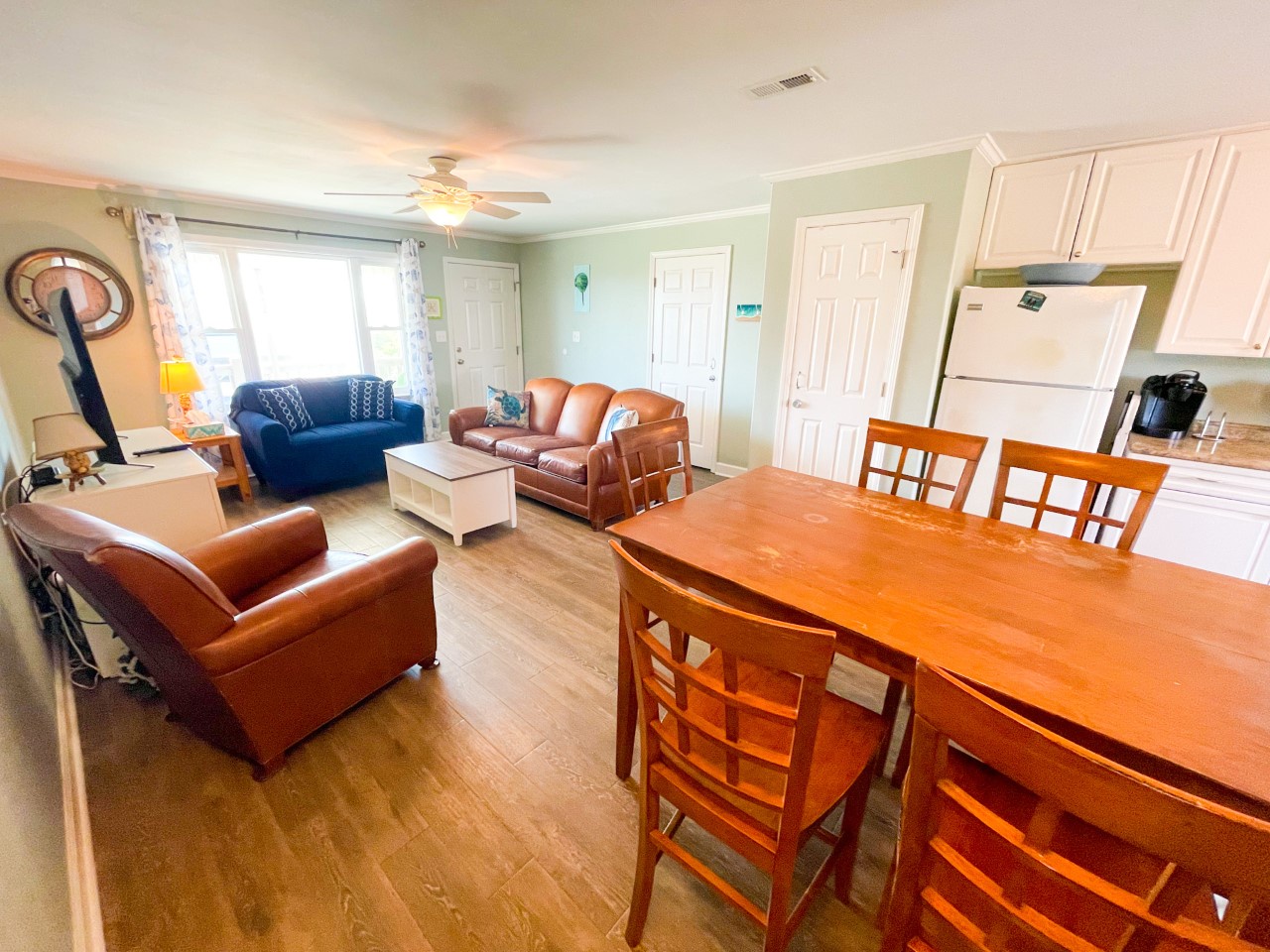 Relax in your open-plan living space featuring leather seating, dining table for six, and fully equipped kitchen with modern appliances.