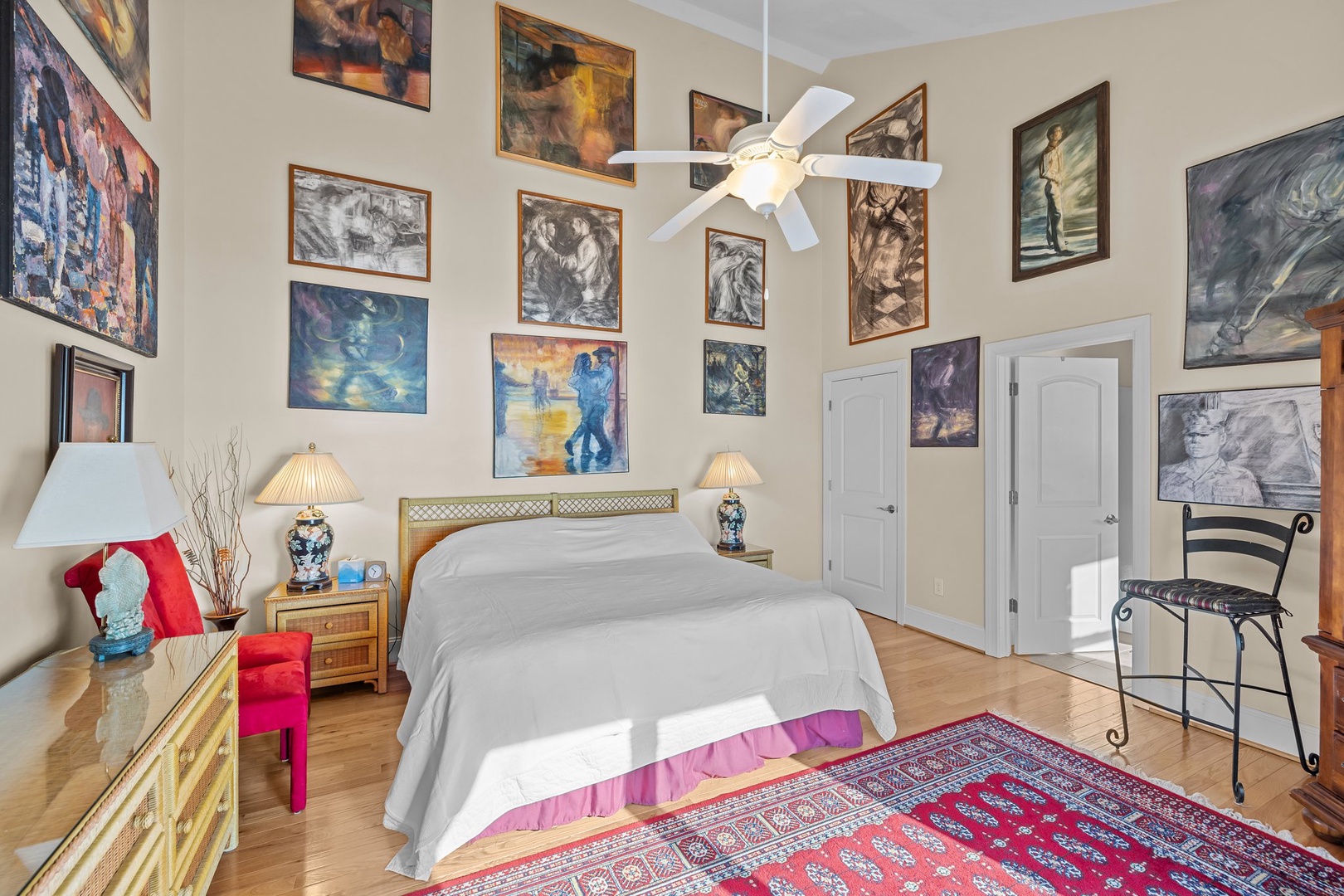 Your artistic retreat features a stunning gallery wall surrounding your comfortable bed, creating an inspiring sanctuary for peaceful nights.