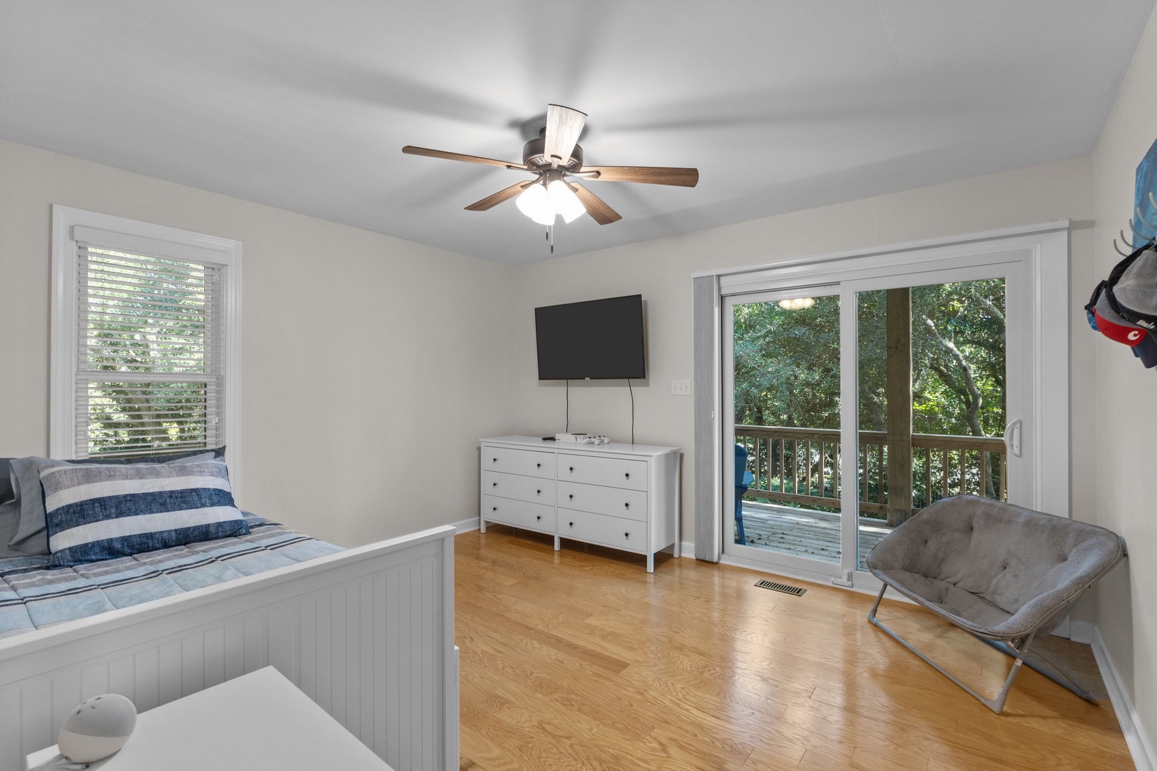 Unwind in your peaceful bedroom with ceiling fan comfort and private balcony access to lush tree views.