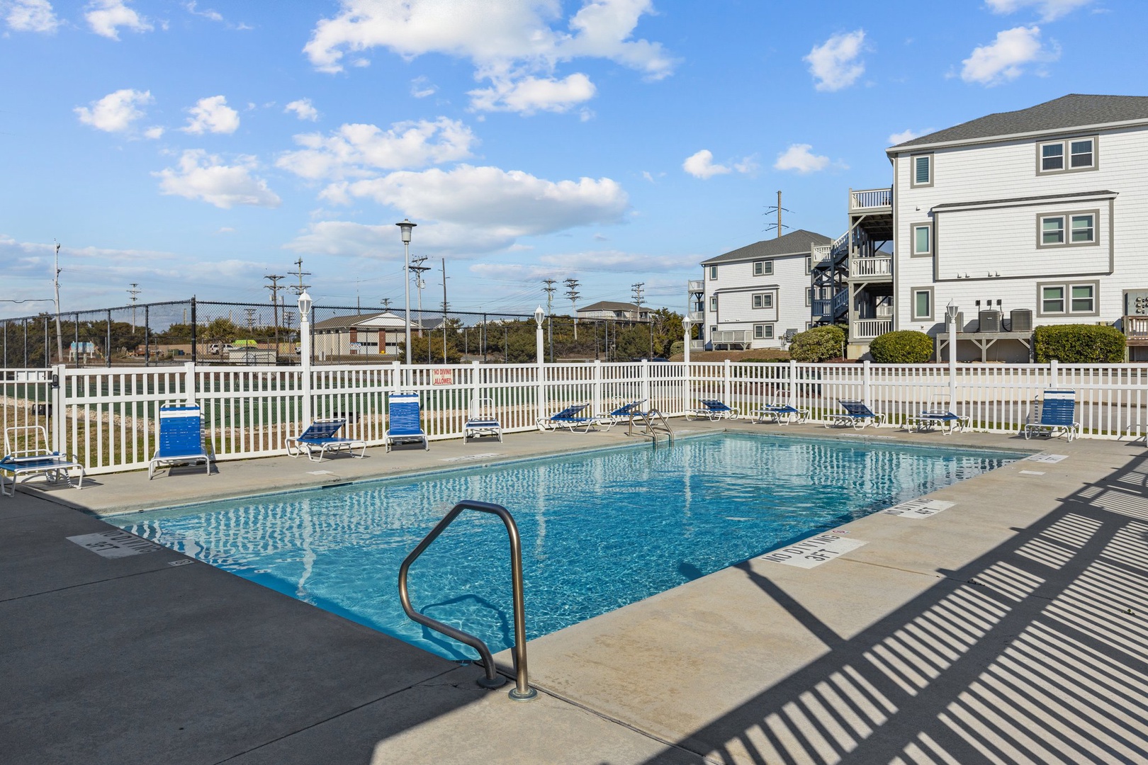 Dive into crystal-clear waters at your private community pool, surrounded by comfortable lounge chairs for sunbathing and relaxation.