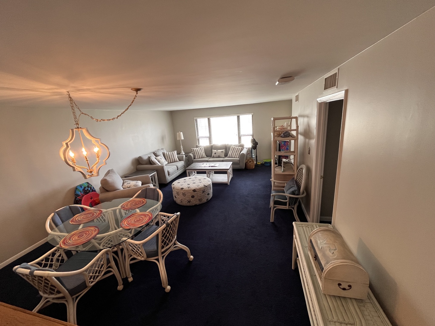 Relax in your spacious living area featuring comfortable seating, elegant lighting, and a dining table where you can enjoy meals together.