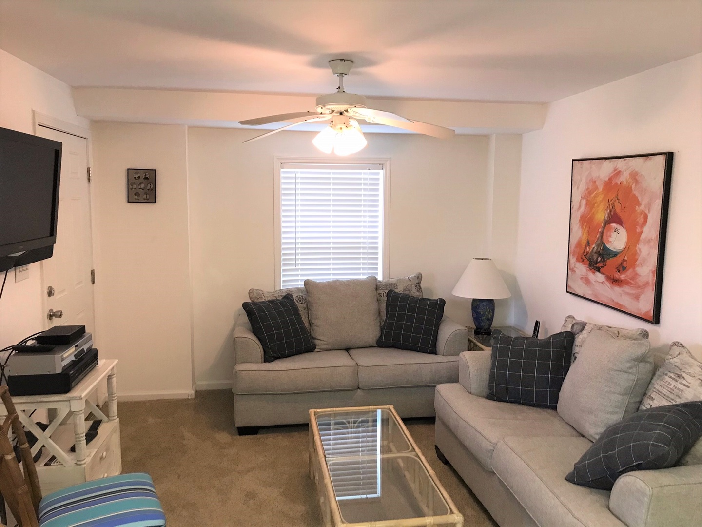 Relax in your cozy living room with plush sofas, ceiling fan, and entertainment center for perfect evenings in.