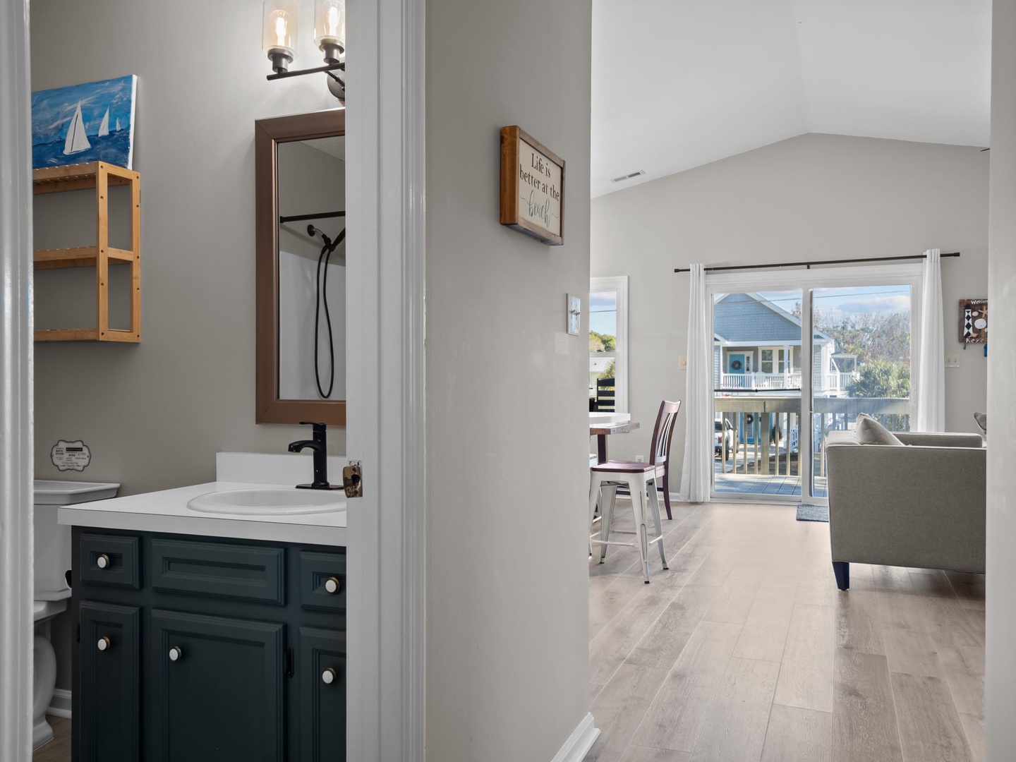 Your stylish bathroom vanity features modern fixtures and coastal charm, connecting seamlessly to your bright living space.
