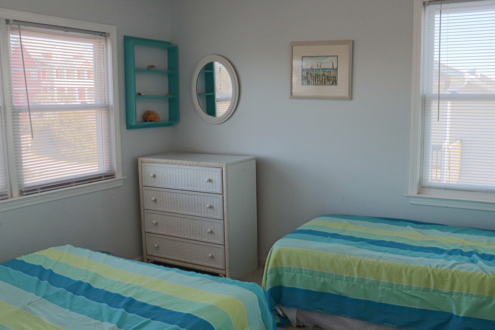 Two comfortable beds with ocean-inspired linens await you in this bright bedroom, complete with ample storage and charming coastal touches.
