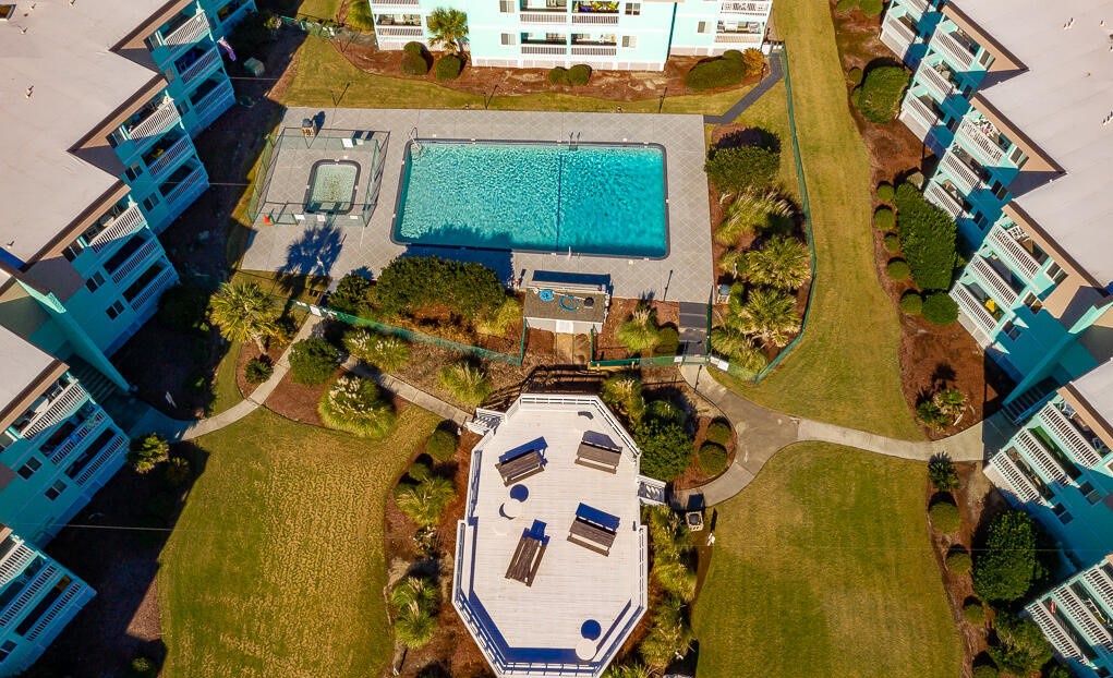 Aerial view of the resort complex showcasing the swimming pool, recreational facilities, and surrounding property buildings with landscaped grounds.