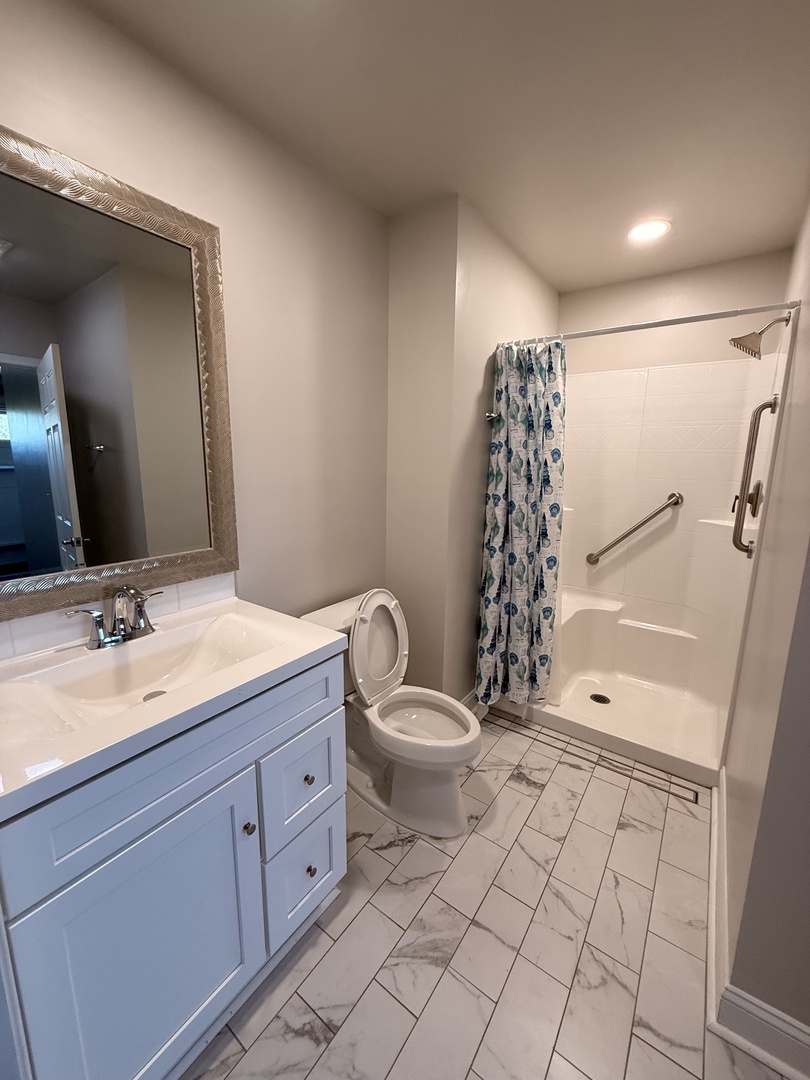 Refresh in your private bathroom with a spacious tub, modern tiled shower, and coastal-inspired accents that bring a calming touch to your daily routine.