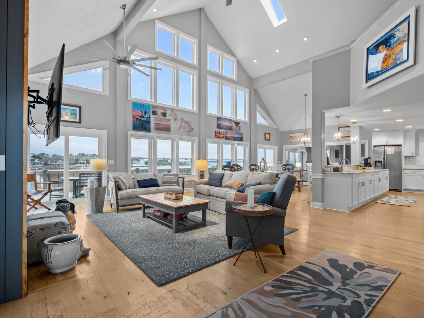 Relax in this stunning open-concept living space where soaring ceilings and expansive windows frame breathtaking water views, creating your perfect coastal retreat.