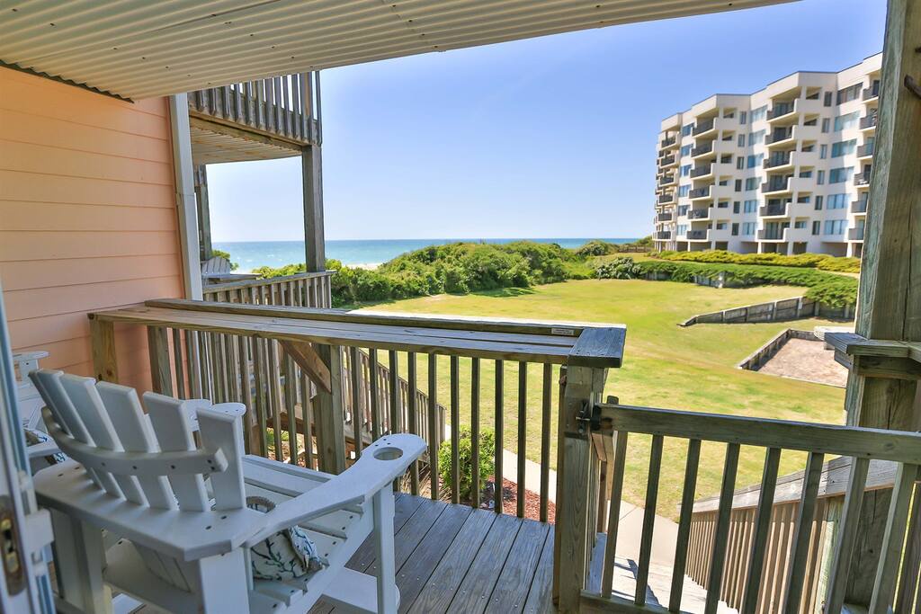 Your private balcony beckons with coastal views across rolling greens to the sparkling ocean beyond.