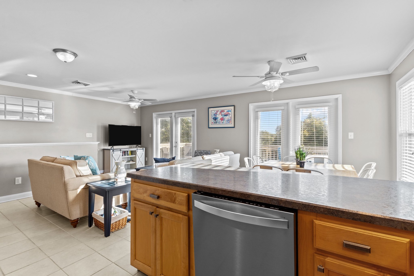 Your bright, open-concept living space flows seamlessly from kitchen to living room, where natural light streams through multiple windows.