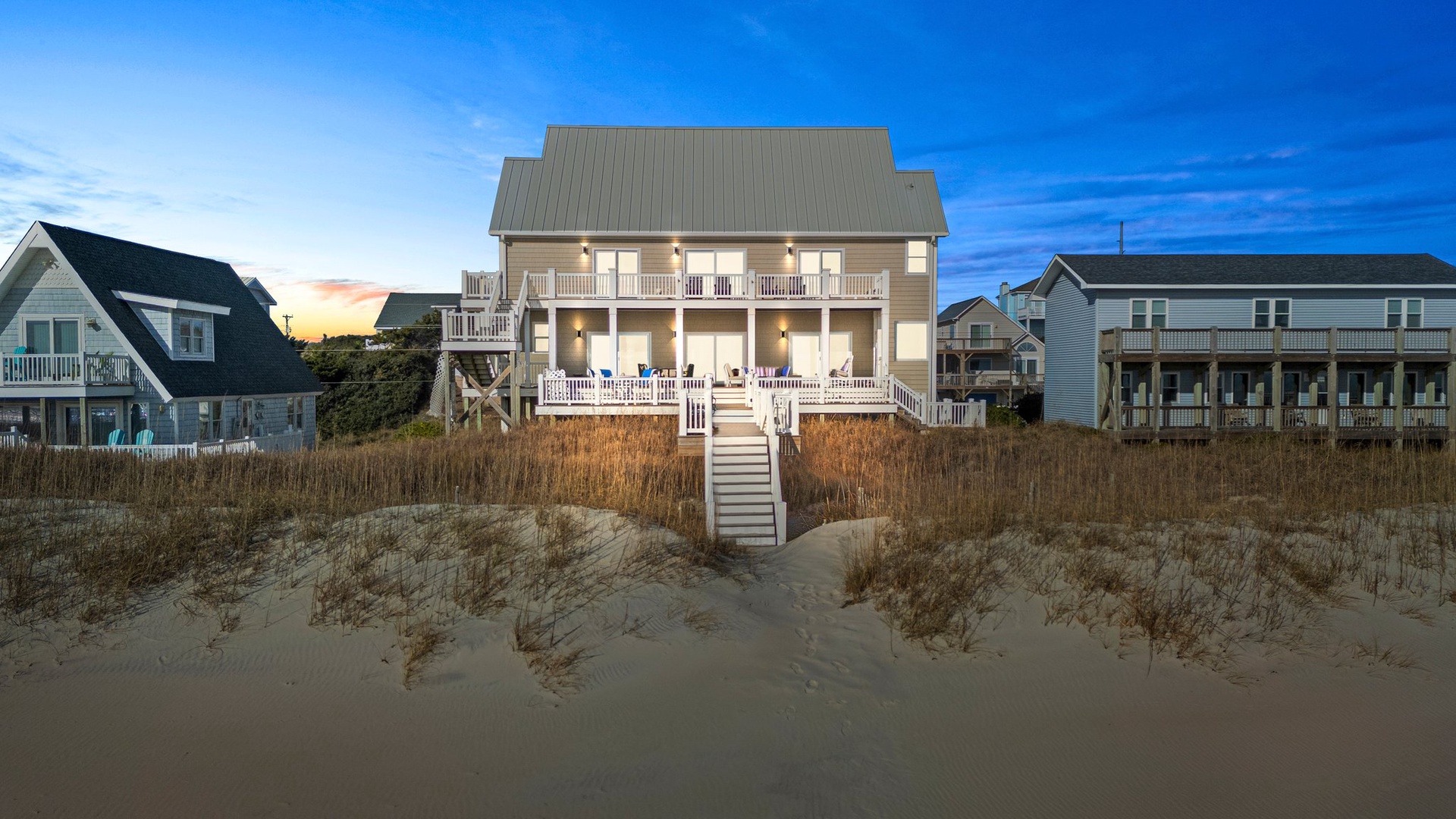 Stunning beachfront property with multiple levels of wrap-around porches, steps from pristine sand dunes in a charming coastal neighborhood.